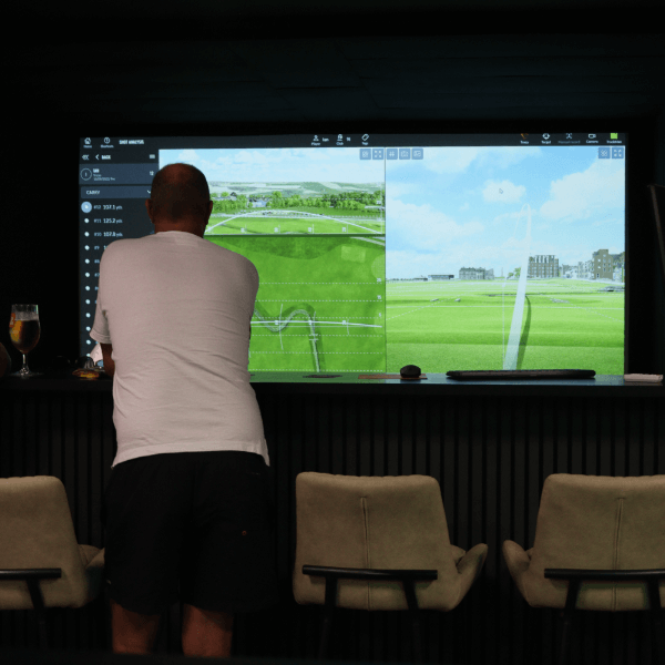 Person watching golf analysis on screen